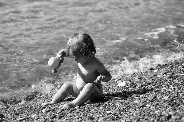 Jongen zit in het zeewater — Stockfoto