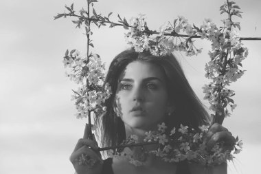 Sevimli kız mavi gökyüzü üzerinde çerçeve çiçek poz