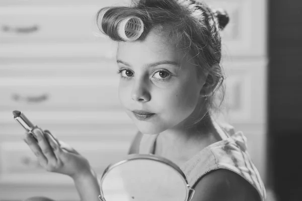 Kid försöker måla läpparna och göra makeup med mammor kosmetika — Stockfoto