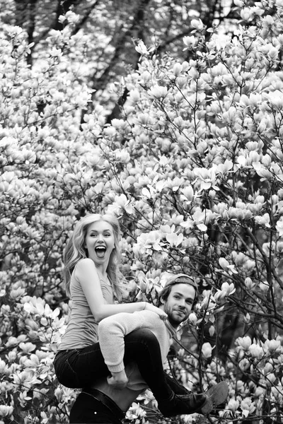 Man och kvinna, par i kärlek i magnolia vårblommor — Stockfoto
