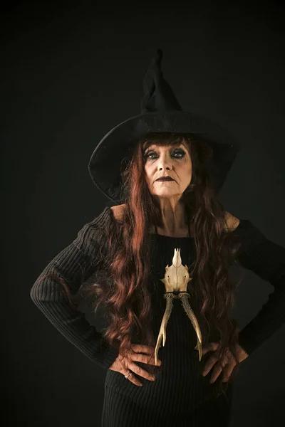 Stará žena s dlouhé červené vlasy v klobouk čarodějnice halloween — Stock fotografie