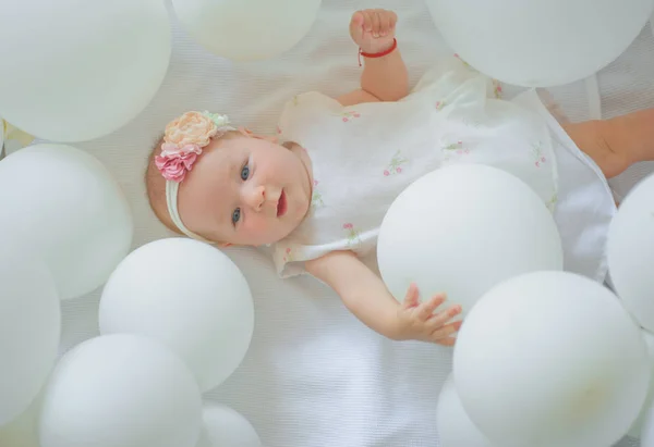 Cute little baby. Family. Child care. Childrens day. Sweet little baby. New life and birth. Portrait of happy little child in white balloons. Small girl. Happy birthday. Childhood happiness