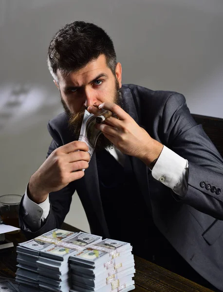 Un riche hipster. L'homme barbu compte les dollars en fumant du cigare. Un homme d'affaires prospère détient de l'argent comptant. Homme riche avec barbe en tenue de cérémonie. Affaires et finances. Gagner de l'argent. Faire croître une entreprise — Photo