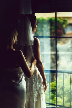 Güzel nedime güzel gelin peçe üzerinde koymak için yardımcı olur.