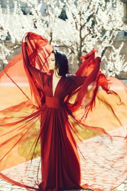 Kayısı çiçeklenme tree yakınındaki güzel bir kadın. Mevsimlik özelliği, güzellik ve moda.