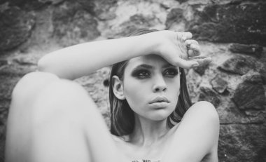 Güzellik model taş duvara sakin ol. Kadın makyaj cilt yüz, yaz gününde cilt bakımı ile. Kadın uzun esmer saçlı, açık saç modeli. Cilt Bakımı, saç bakım, tedavi, tedavi için kız.