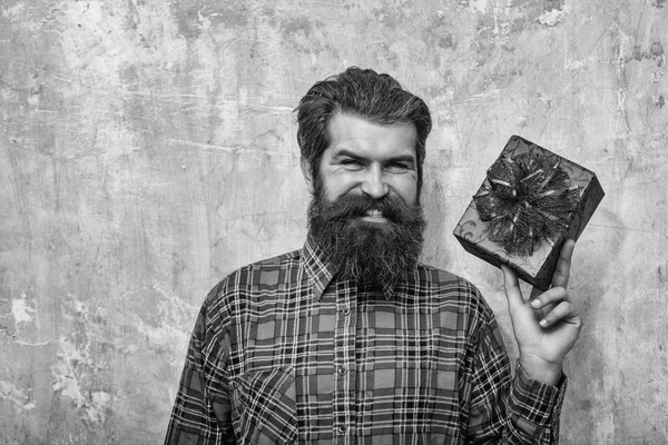 Feliz hombre barbudo sonriendo con caja de regalo roja con arco — Foto de Stock