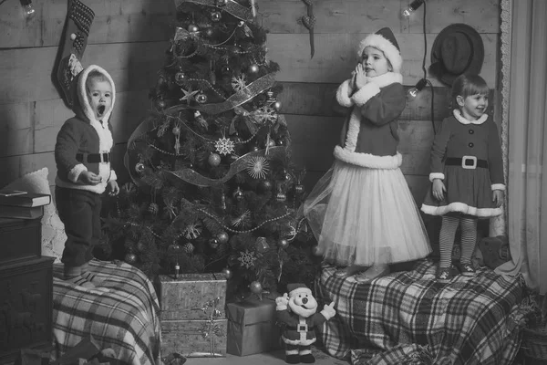 Weihnachtsglückliche Kinder am Neujahrsbaum — Stockfoto