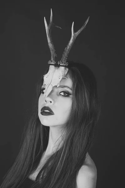 Fashionable girl or woman with makeup and antlers. girl in strange skull antlers or horns. — Stock Photo, Image