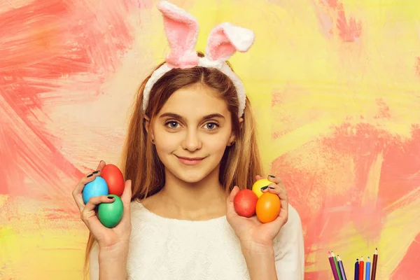 Feliz chica de Pascua en orejas de conejo con huevos, conjunto de lápices — Foto de Stock