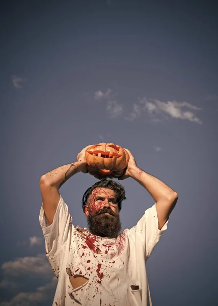 Halloween homem segurando cabeça de abóbora no céu azul — Fotografia de Stock