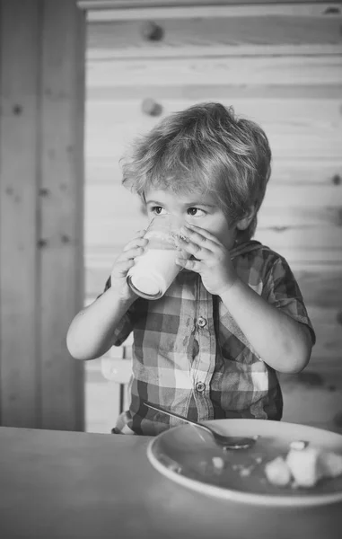 Mały chłopiec dziecko jeść bananów i piciem mleka. — Zdjęcie stockowe