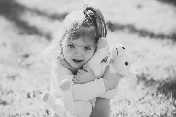 Bebé niña abrazo suave caballo juguete en día soleado —  Fotos de Stock