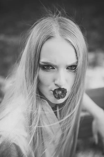Schönheit Frau mit roter Blume im Mund. Schönheitsmodel mit langen blonden Haaren, Frisur. — Stockfoto