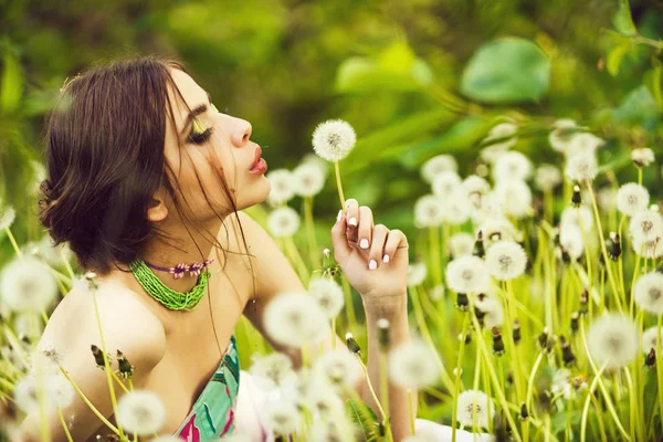 Jovem com maquiagem elegante e contas em folhas verdes — Fotografia de Stock