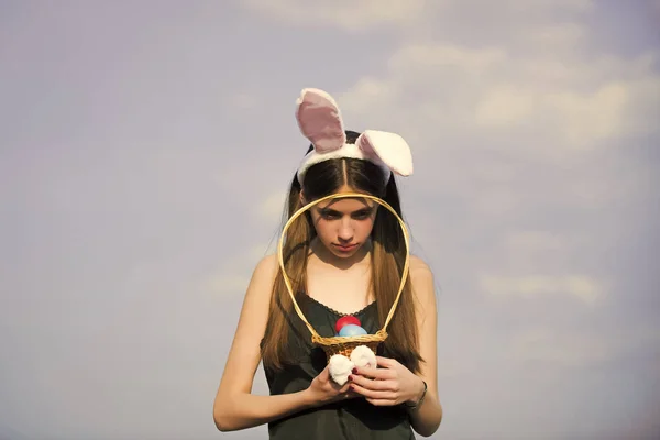 Mujer de Pascua sosteniendo cesta de mimbre con huevos de colores — Foto de Stock