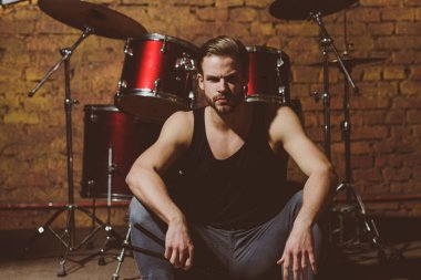 Orada müzik. Enstrümantal müzik keyfi. Yakışıklı adam vurmalı enstrüman aşamada oturamaz. Müzik aleti ile adam davulcu. Rock müzik kulübü provada. Rock yıldızı ya da rock'çı