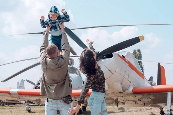 Létání jako pták. Žena a muž s chlapcem dítě na vrtulník. Šťastné rodinné dovolené. Rodinné dvojice se synem na dovolené cestovat. Air tour a cestování. Těší, v letecké dopravě — Stock fotografie