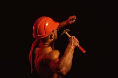 Hala yapım aşamasında. Sert işçi kullanımı kas gücü. Adam iş çekiçle. İnşaat işçisi bir çivi çekiç. Kaslı adam Oluşturucusu yapım aşamasında işyerinde