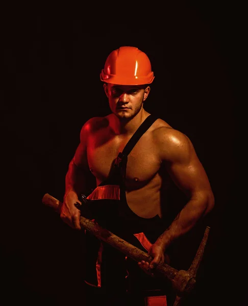 We renovating, under construction. Construction worker. Muscular man worker. Hard worker with muscular torso. Man miner with mining equipment. Mining area under construction