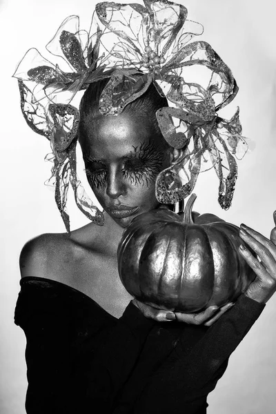 Mujer dorada con calabaza de halloween —  Fotos de Stock