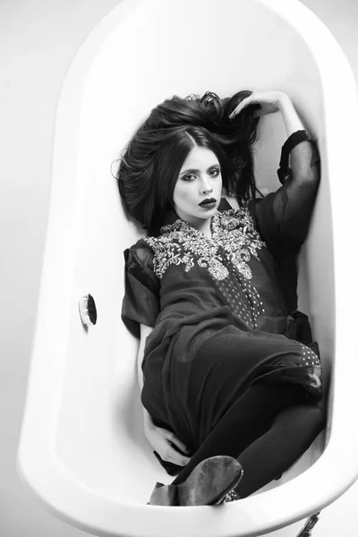Weiße Badewanne und schöne junge Frau mit schwarzen Lippen — Stockfoto