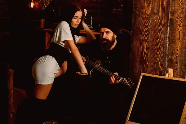 Playing from his heart. Romantic couple of brutal man and sexi woman. Bearded man play guitar to sexy woman. Couple in love enjoy music. Rock style couple of lovers. Man guitarist play for girlfriend — Stock Photo, Image