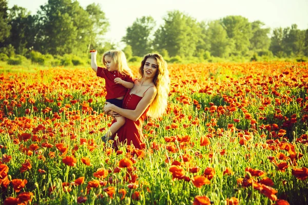 Frau und kleiner Junge oder Kind im Mohnfeld — Stockfoto