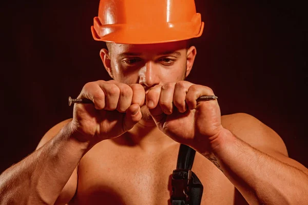 You can rely on. Strong man with muscular arms. Muscular man bend nail. Construction worker or builder with biceps triceps. Worker or workman in safety helmet. Strong and full of power — Stockfoto