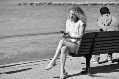 Telefonu bankta olan kadın.