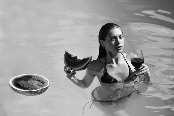 Mulher com melancia e vinho na piscina — Fotografia de Stock