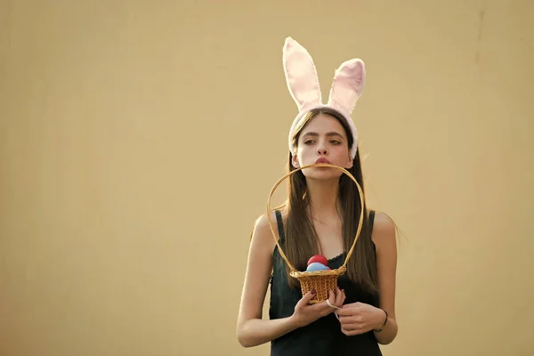 Easter girl with rosy bunny ears on beige background — Stock Photo, Image