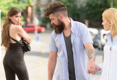 Sokakta flört. Aşk üçgeni ve üçlü. Adam sevgilisini aldatıyor. Diğer kıza baktığını sakallı adam. İki kadın arasında seçme hippi. İhanet ve aldatma. Sadakatsiz aşk