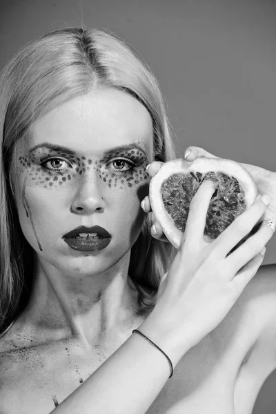 Hübsche blonde Frau mit kreativem modischem Make-up halten Grapefruit, Vitamin — Stockfoto