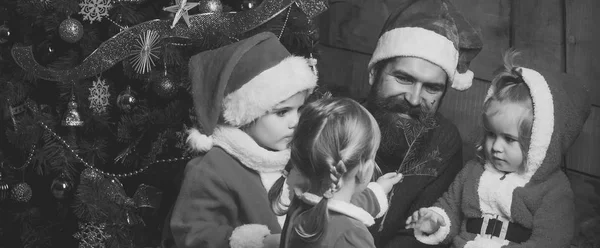 Weihnachtsmann-Kind und bärtiger Mann am Weihnachtsbaum. — Stockfoto