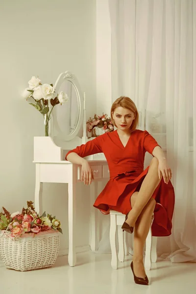 Kvinna i röd klänning. sexig kvinna grooming i morgon på spegeln. sovrum inredning för eleganta kvinnan. självsäker och vacker. Vara en kvinna som en Man behöver. — Stockfoto