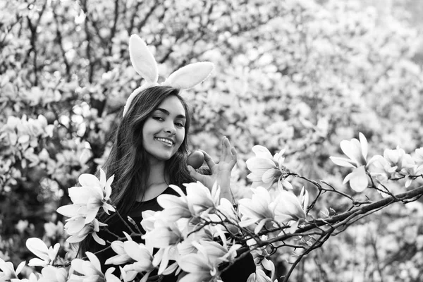 Femme heureuse souriant avec oeuf rouge coloré à magnolia arbre — Photo