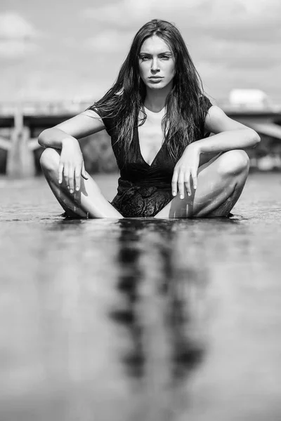 Fiatal szexi nő ül a vízben — Stock Fotó