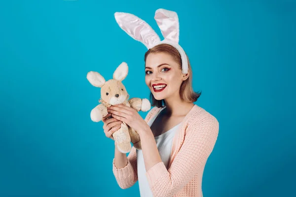 Gelukkige vrouw in bunny oren met speelgoed. Voorjaar vakantie. Meisje met Haas speelgoed. Egg hunt. Paaseieren als traditionele gerechten. Vrolijk Pasen. Vrouw in konijn bunny oren. Kopieer ruimte. Funny bunny — Stockfoto