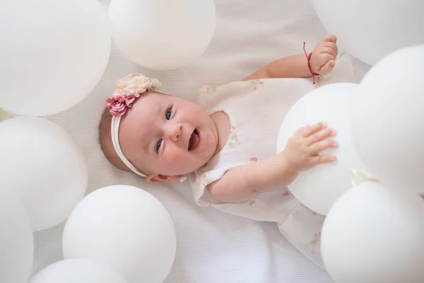 Pure beauty. Small girl. Happy birthday. Portrait of happy little child in white balloons. Sweet little baby. New life and birth. Childhood happiness. Family. Child care. Childrens day