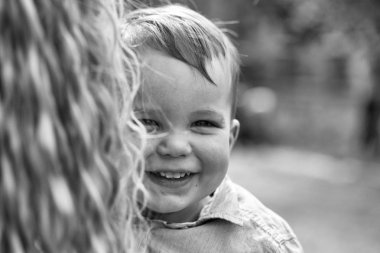 Annenin kollarında gülümseyen şirin mutlu bebek çocuk