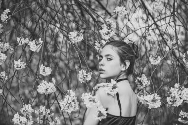 Kadın poz ağaçların çiçek açması çiçekler içinde