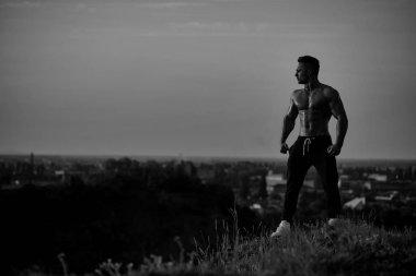 Gökyüzü arka plan üzerinde seksi kaslı adam