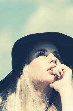 Şapkalı güzel bir kadın. Retro moda. mavi gökyüzü arka plan üzerinde büyük ağzına kadar ile yaz şapka