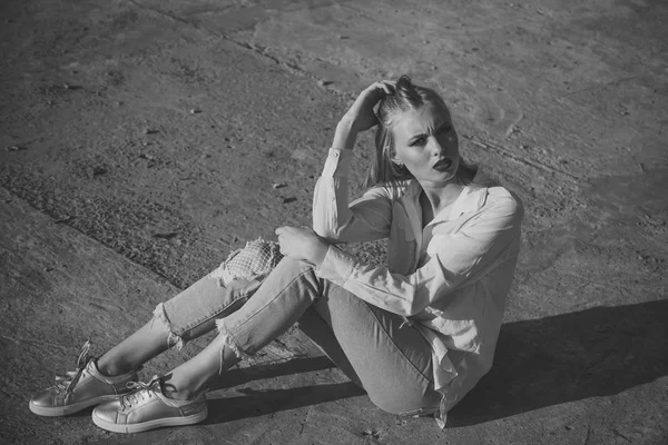 Vrouw zitten op cement grond, mode. — Stockfoto