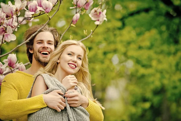 Mann und hübsches Mädchen oder süße Frau genießen rosa Magnolie — Stockfoto