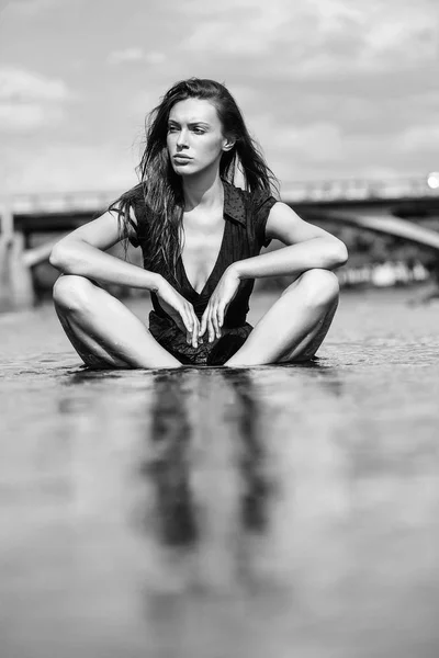Jovem mulher sexy sentado na água — Fotografia de Stock