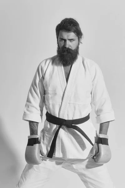 Bearded serious karate man in kimono and boxing gloves — Stock Photo, Image