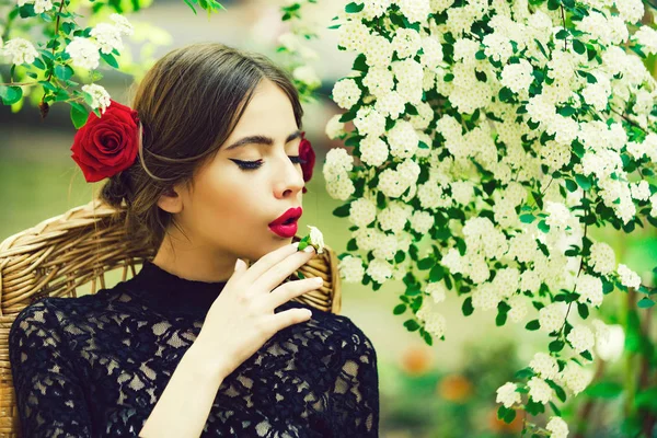 Dívka s bílou květinou v ústech na zamyšlenou tváři — Stock fotografie