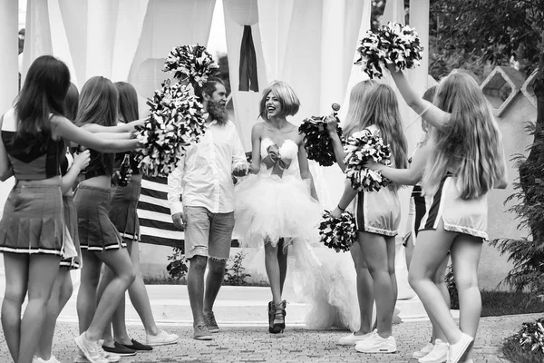 Wedding couple with cheerleaders — Stock Photo, Image